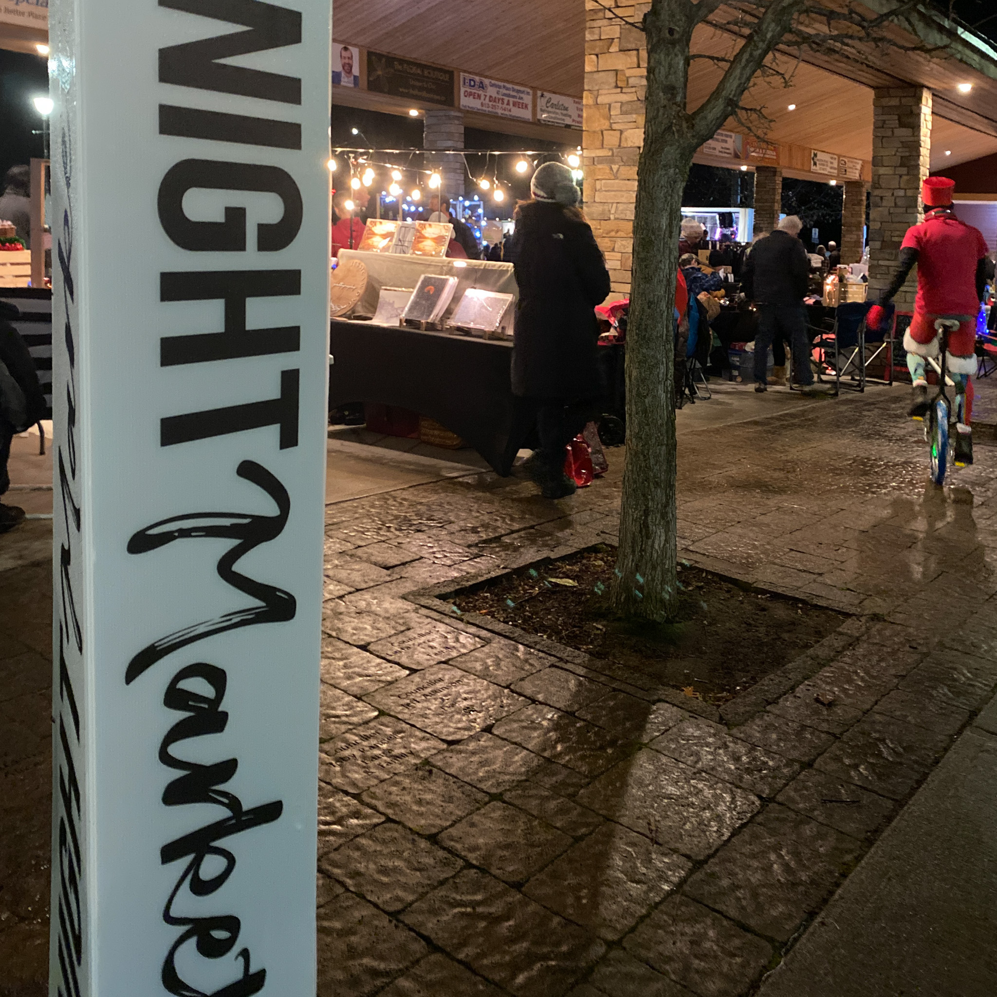 Nigh Market Sign and a perfomers on a unicycle at Winterfest
