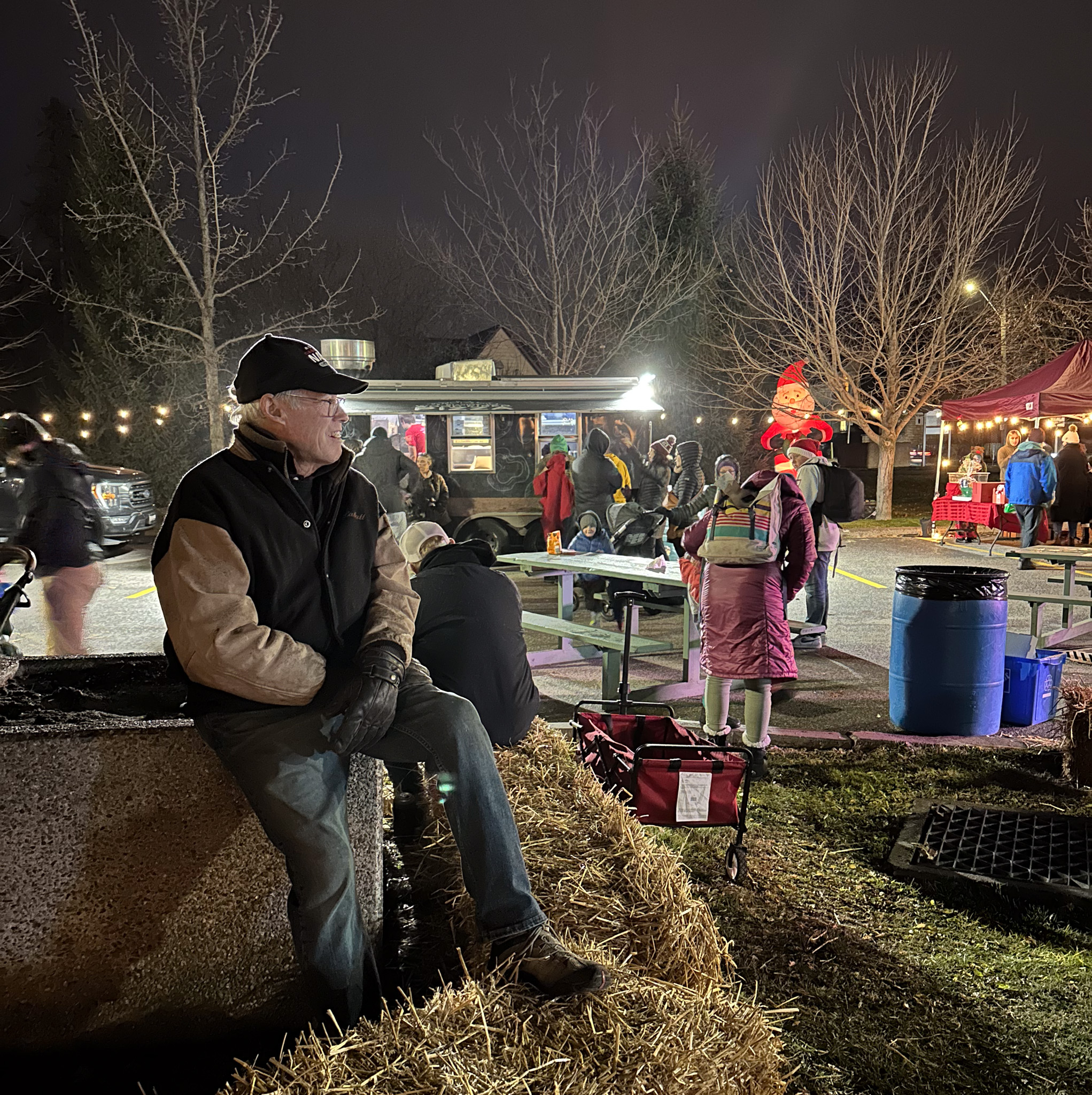 Man rests on Hay Bale and takes in Winterfest