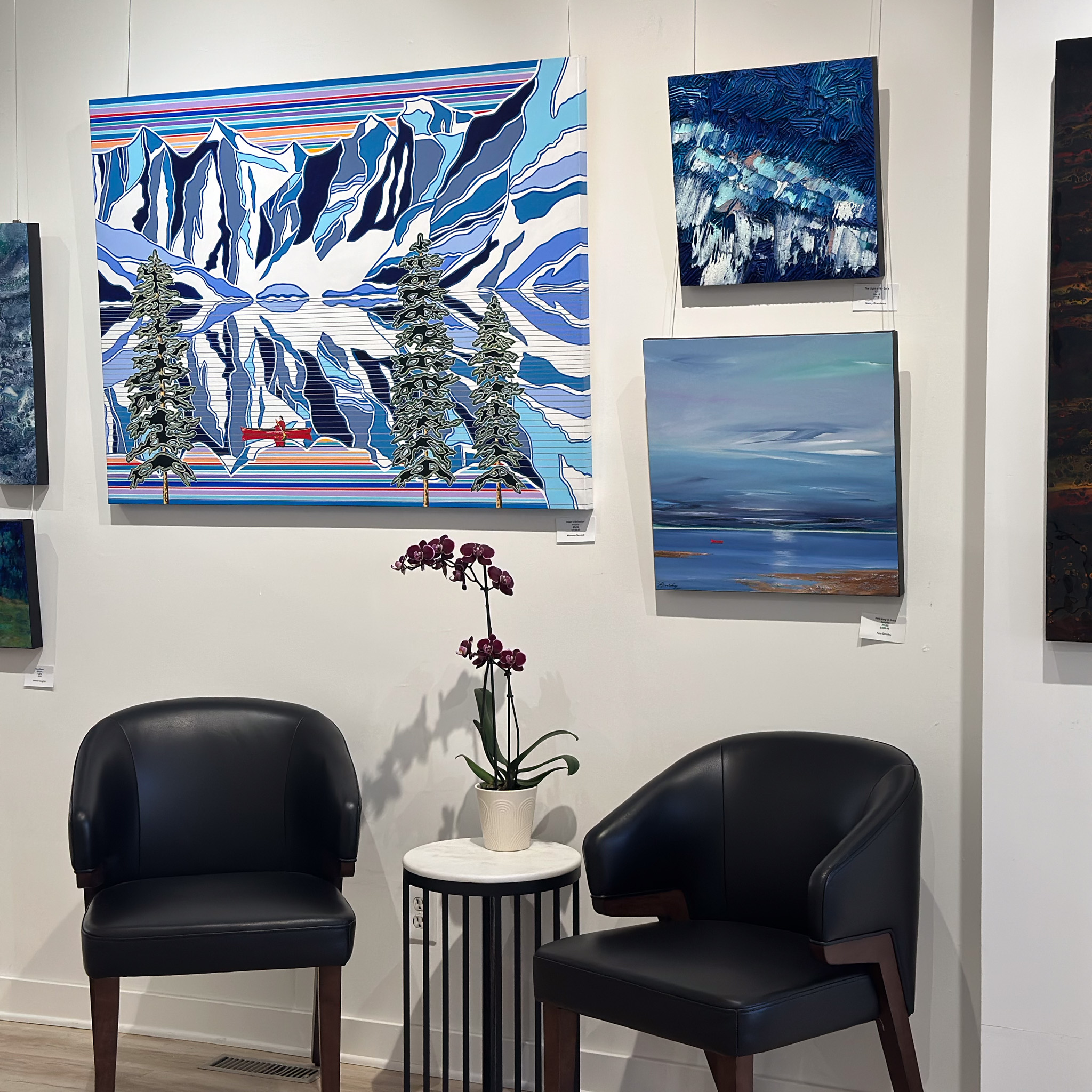 Two Chairs sit under blue artwork with a graphic wintery landscape
