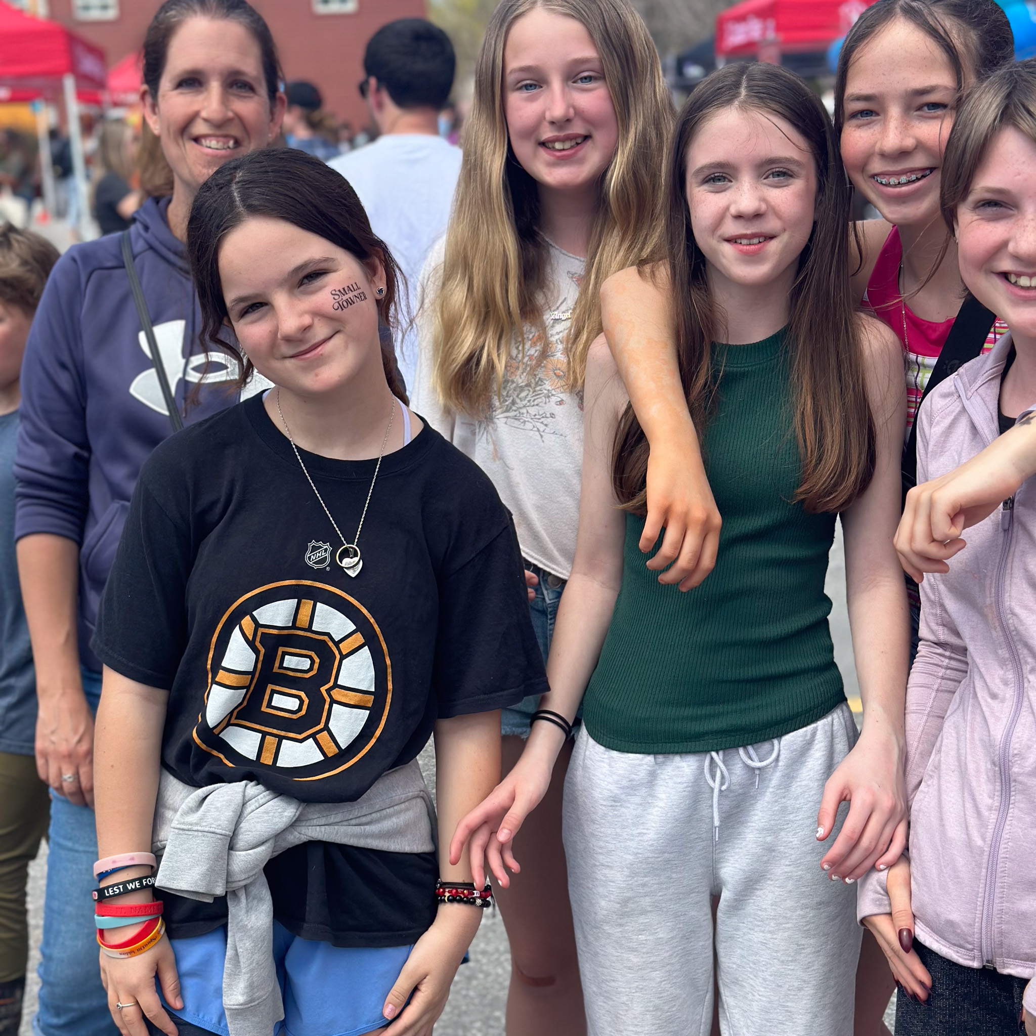 Girls gather at a celebration with Small towner tattoo on her cheek