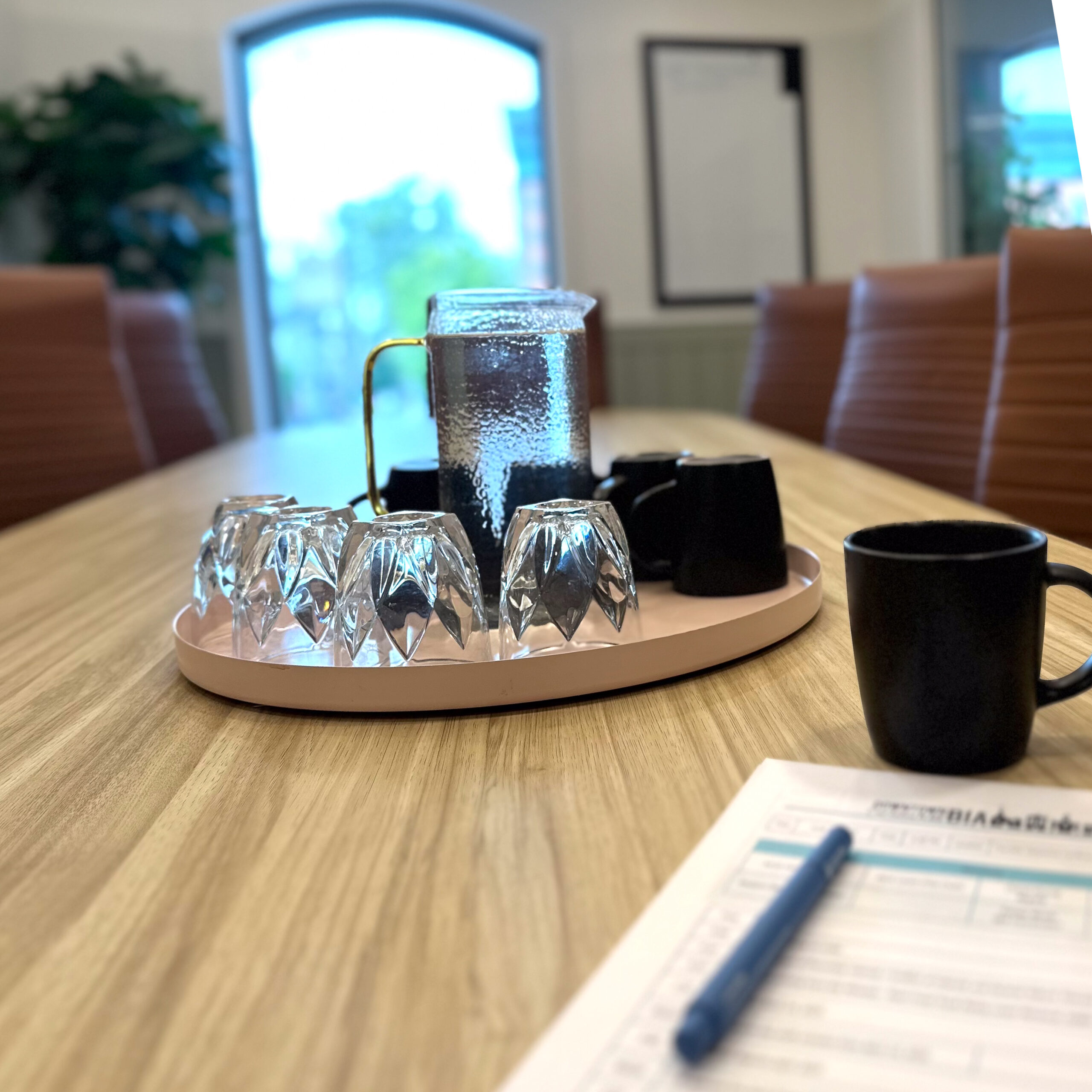 Water and mugs in the centre of a conference table in the Foundry Collective Boardroom 